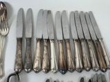 a lot of knives and spoons on the table