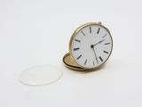 une bague en or surmontée d'une horloge blanche