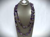 a close up of a necklace with purple beads on a mannequin