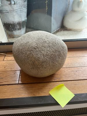 a rock sitting on a window sill next to a window sill