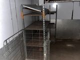a metal cage with shelves in the middle of a room