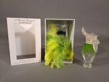 a box with a bottle of perfume next to a box with feathers