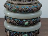 three stacked bangles sitting on top of a wooden table next to a white wall