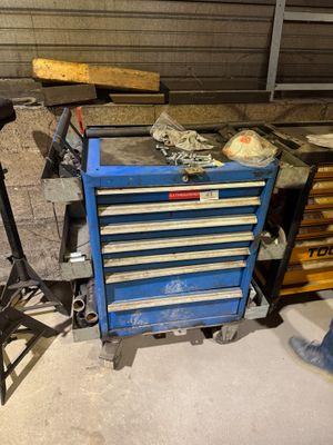 une boîte à outils bleue sur laquelle est posée une batte de baseball
