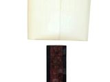 La lampe de table est en bois et est équipée d'un abat-jour blanc.
