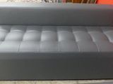grey leather sofa in front of a red wall in a living room