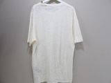white t - shirt hanging on a hanger against a wall