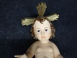 a small doll with a gold crown on it ' s head