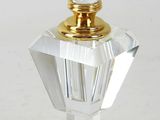 clear glass perfume bottle with a gold top sitting on a white surface