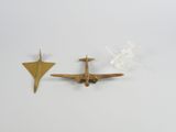 deux petits avions en laiton posés l'un à côté de l'autre sur une surface blanche