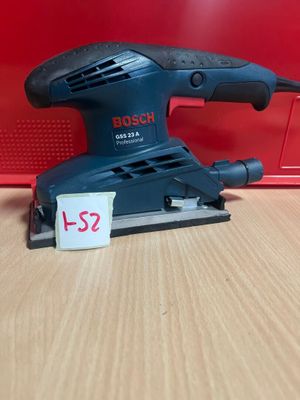 une ponceuse orbitale Bosch posée sur une table, avec son étiquette de prix