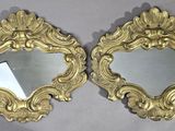 une paire de miroirs en or richement décorés sur fond blanc