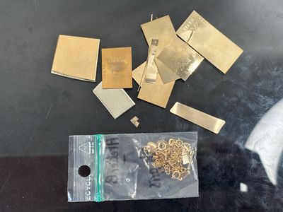 a bag of gold pieces on a table next to a pair of scissors and a pair of scissors