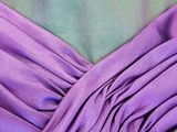 close up of a purple dress with a green and blue background
