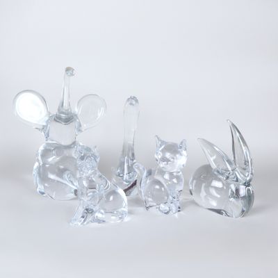 three glass figurines of animals sitting on a white surface