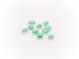 a group of green glass beads on a white surface