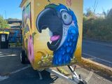 a trailer with a painting of a parrot on the side of it