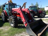 two red tractors that are parked in the grass