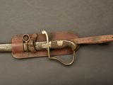 a picture of a knife with a leather sheath on it