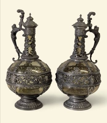 deux vases en argent posés l'un à côté de l'autre sur une table