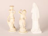 two white statues of women holding vases and a statue of a man