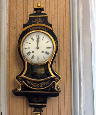 une horloge à chiffres romains accrochée au mur