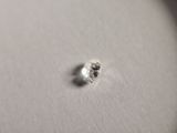 a close up of a tiny piece of metal on a white surface