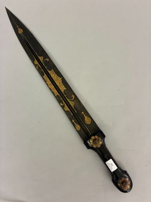a close up of a black and gold knife on a white surface