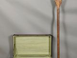 une valise verte avec une poignée en bois à côté d'une valise verte