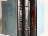 trois livres sont empilés sur une table