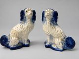 pair of blue and white porcelain dog figurines on a gray background