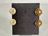 two pairs of pearl and gold earrings on a black surface