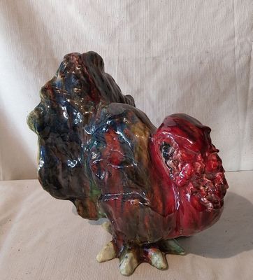 une sculpture en céramique représentant un coq sur fond blanc