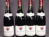 quatre bouteilles de vin sont alignées sur une table