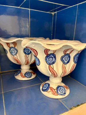 deux vases posés sur une étagère dans une pièce carrelée de bleu