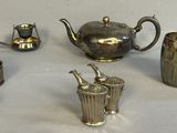 silver plated teapots, cups, and vases on a table