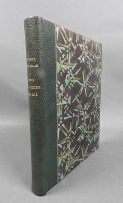 un vieux livre à la couverture verte posé sur une table