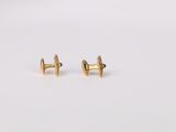 a pair of gold plated earrings on a white surface