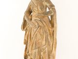an old statue of a woman with a hat and dress