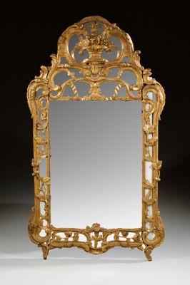 an ornately carved mirror with a gold frame on a black background