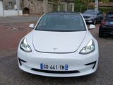 a white tesla car parked in a parking lot