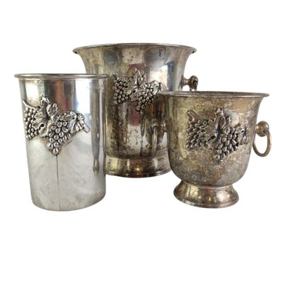 three silver vases with pinecones on them sitting next to each other