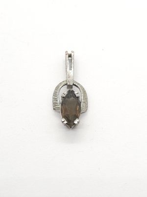 un gros plan d'un pendentif en argent orné d'une pierre marron