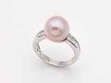 une bague en perle rose et diamants sur fond blanc
