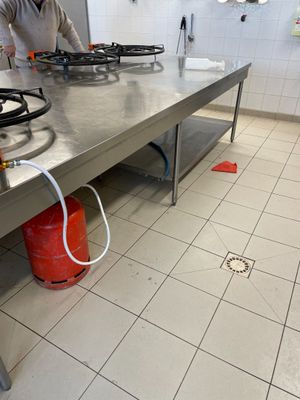 une femme debout dans une cuisine devant une cuisinière