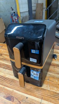 une cafetière noire et dorée posée sur une table en bois