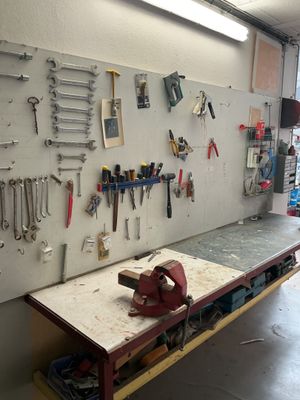 a workbench with a lot of tools hanging on the wall