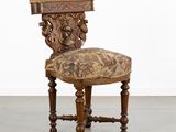 une chaise ancienne avec une assise rembourrée à motifs floraux et des pieds en bois