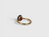 a gold ring with a red stone in the middle