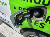 a green car with a gas pump attached to it ' s side
